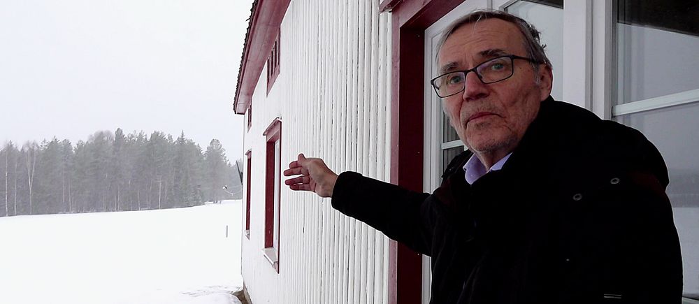 Peter Malmström i Kannusjärvi står vid sitt hus och pekar ut mot var vindkraftsverken planeras byggas.