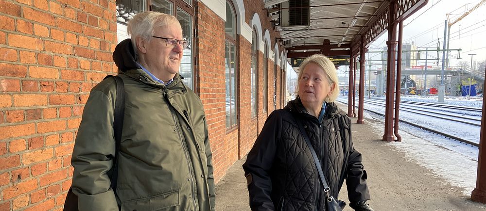 man och kvinna väntar på tågperrong