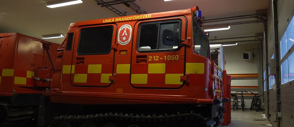 En bandvagn med räddningstjänstens färger i ett stort garage