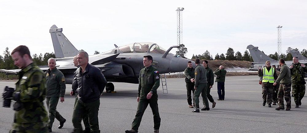 Flera stridspiloter och personal rör sig på Kallax flygfält i Luleå.