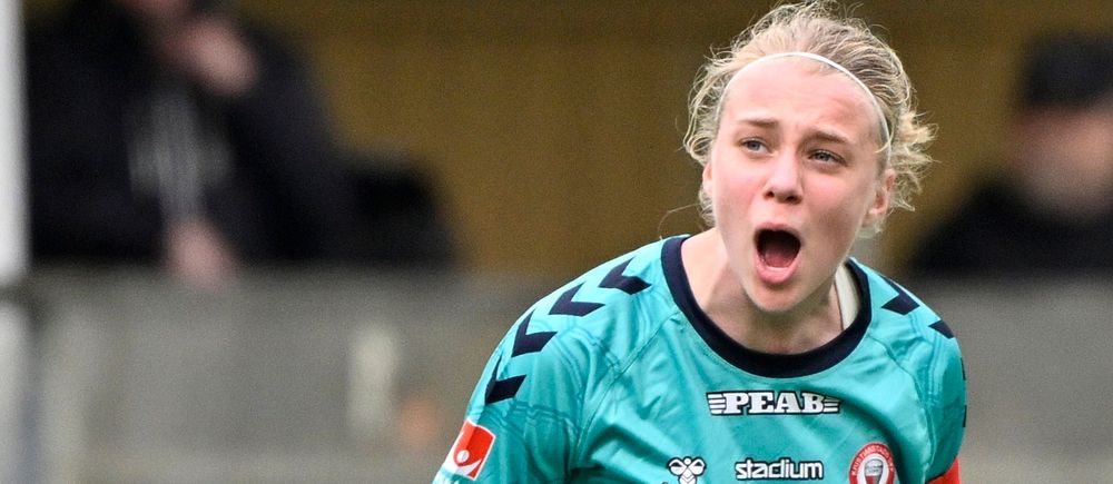 Fotbollsspelare i grönblå matchdräkt på planen under match.