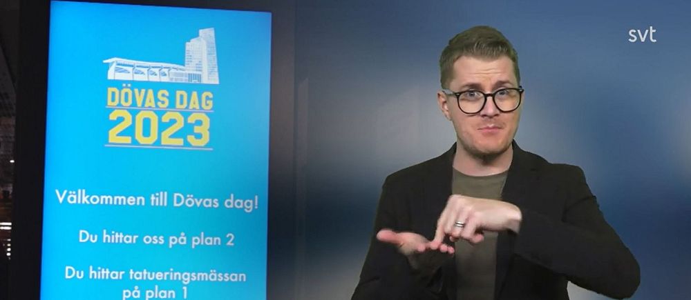 Magnus Bergevin tecknar ”Malmö” bredvid en bild med Dövas dag-logotypen