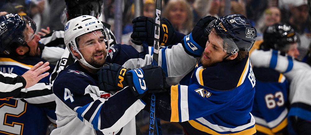 Hockeyspelare från två lag i tumult på isen under en match.