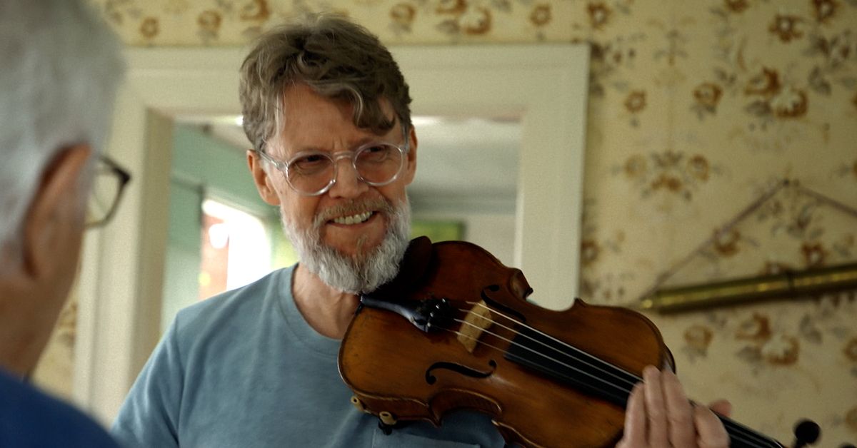 Mikael Gyllström spelar fiol hemma i ett vardagsrum