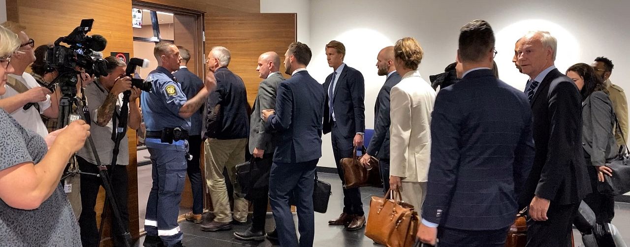En stor mängs press, advokater och andra kostymkläddda män och kvinnor släpps in i tingsrättssalen.