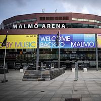 Bild på Malmö Arena med skyltar om Eurovision.