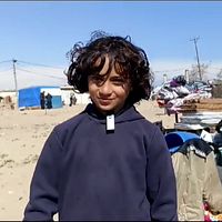 Pojke står vid tältlägret i Rafah.