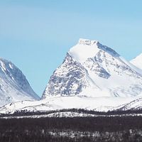 Vy över snötäckta fjäll iNnorra Lappland.