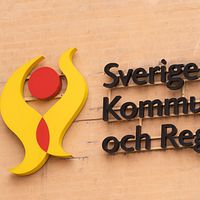 Vägg med skylt som säger Sveriges kommuner och regioner (SKR)