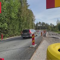 Vägarbete med risk för skador på bilar. Bil som försiktigt kör förbi.