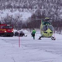 En ambulanshelikopter på marken i ett snöklätt Abisko i samband med räddningsinsatsen efter lavinolyckan där två heliskiåkare dog.