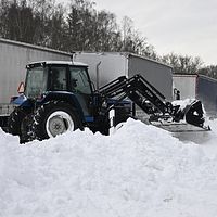 traktor på e22 med mycket snö lastbilar som kört fast