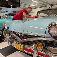 Roine Nilsson putsar på sin veteranbil hemma i garaget
