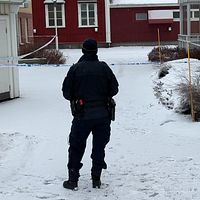 Avspärrning efter misstänkta mordförsöken i Skellefteå. En polis i förgrunden.