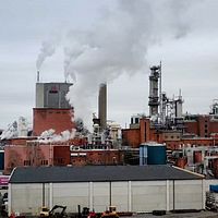 Aspa bruk i Olshammar utanför Askersund, fabrik i rött tegel med rykande skorstenar intill Sörviken i Vättern där pappersmassatillverkaren släppt ut rester i snart 100 år