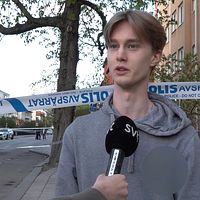 Person intervjuas framför polisavspärrning på gata i bostadsområde.