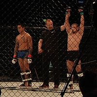 Två MMA-fighters, domaren utser vinnaren som höjer händerna i oktagonen.