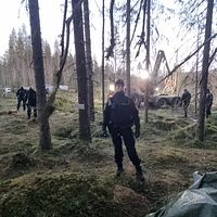 Poliser rör sig genom en skog.