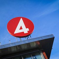 TV4-logga på byggnad mot klarblå himmel.