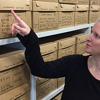 Jenny Bergman, antikvarie på Historiska museet vid Lunds universitet står i museets magasin och pekar mot en av lådorna med titeln ”Anatomiska samlingen” som innehåller samiska kvarlevor.