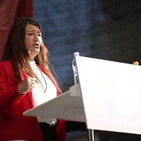 En kvinna i röd kavaj i en talarstol