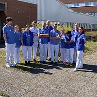 En grupp läkare står utanför Sundsvalls sjukhus. De är oroliga för att  bristen på sjuksköterskor ska hota patientsäkerheten vid sjukhuset i sommar.