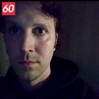 Mörk interiör med skymd sikt på en Rickard Andersson i en hoodie.