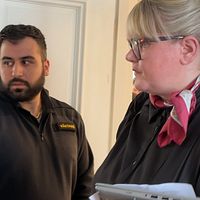 Moderatpolitikern Viktoria Jansson på väg ut ur fullmäktigasalen. En väktare tittar på.