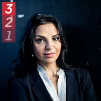 Person i kostym framför mörk bakgrund.