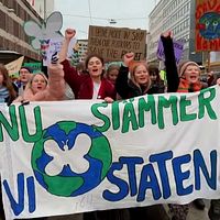 Stor grupp ungdomar demonstrerar på gata utomhus i Stockholm, klimataktivister i gruppen Aurora med banderoll som säger ”Nu stämmer vi staten”.
