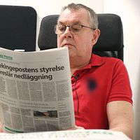 Blekingepostens chefredaktör Lars-Göran Enarsson sitter med en tidning.