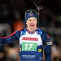 En skidskytt i tävlingskläder med gevär på ryggen. Nummer 17 på bröstet.