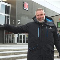 Mikael Johansson, avgående vd för Örebro hockey, står utanför Behrn arena i varm jacka och pekar åt vänster.