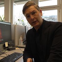 Christoffer Wendick sitter vid en dator på SVT:s redaktion