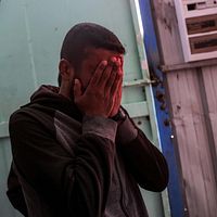 En man sörjer med ansiktet i händerna. Bilden är tagen från ett sjukhus i Beit Lahia i norra Gazaremsan.