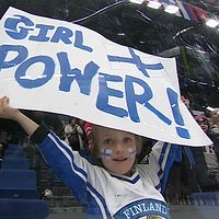 En ung finsk ishockeysupporter håller upp en skylt med texten ”Girl power”