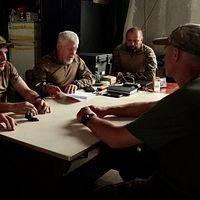 Ukrainska farbröder sitter runt ett bord iförda militärkläder