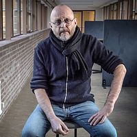 Borlänge kommuns socialchef Tomas Ahlin sitter i en korridor med tegelvägg och fönster.