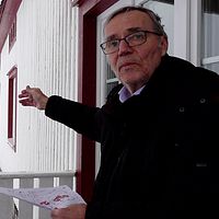 Peter Malmström i Kannusjärvi står vid sitt hus och pekar ut mot var vindkraftsverken planeras byggas.