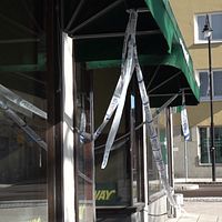ett skyltfönster till en restaurang, med polisens avspärrningsband framför fönster och dörr