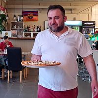 En bild på Lars Norén och på pizzabagaren Riad som döpt en pizza efter kändisen.