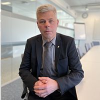 Tvådelad bild. Till vänster: korridor i fängelsemiljö. Till höger: Man i kostym med knäppta händer.