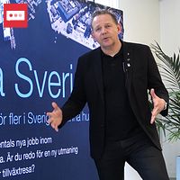Karlskronas näringslivsutvecklare Marcus Fredricsson framför kommunens kampanjskylt med texten Hallå Sverige.