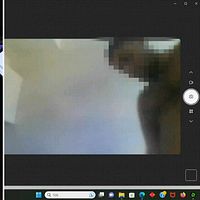 Hackaren sitter vid dator, bild på en av ligans frontfigur som visar sig i en webbkamera.
