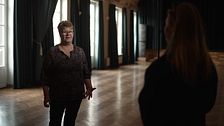 Finska föreningen i Stockholms ordförande Seija Sjöstedt intervjuas i mörkt rum med stora fönster och långsträcka gardiner.