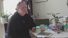 Anita Engström sitter vid ett bord med en telefon i handen