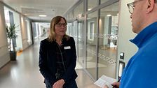 Kvinna intervjuas av reporter i en korridor