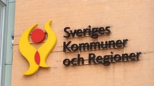 Vägg med skylt som säger Sveriges kommuner och regioner (SKR)