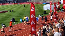Tre tävlande hjälper en kille i mål på Stockholm Marathon