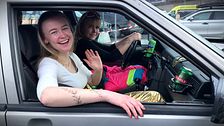 Två glada tjejer sitter i bil i Åre